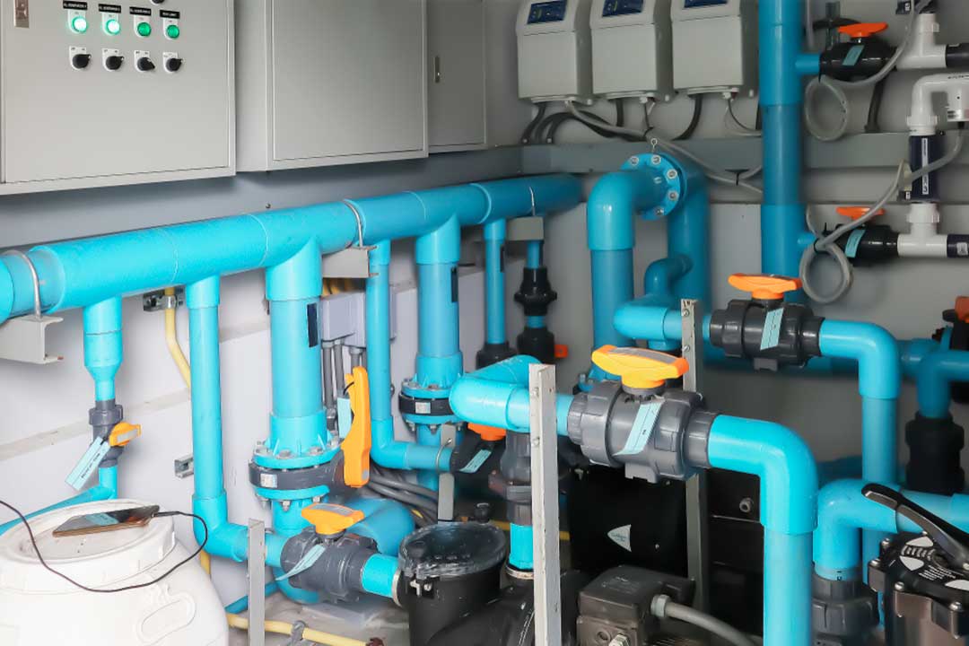 Commercial pool equipment room with hydraulic manifold, valves, and circulation plumbing